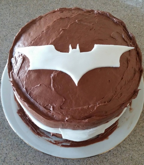 Chocolate cake with a 2000s Batman logo made of white fondant