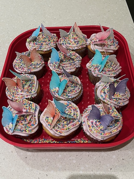 Twelve cupcakes with edible paper butterflies