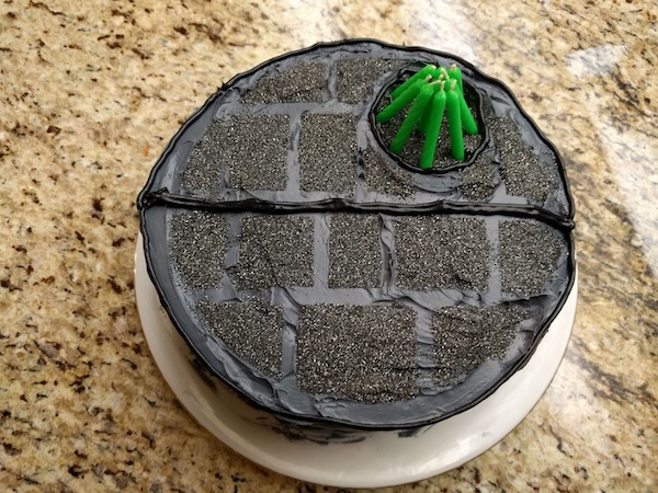 Round Star Wars Death Star cake with green candles shaped into a laser