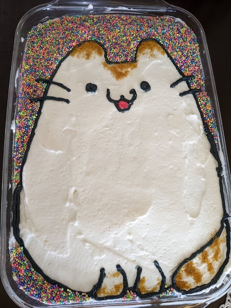 Cake with a drawing of Pusheen the cat but as a flame-tipped siamese