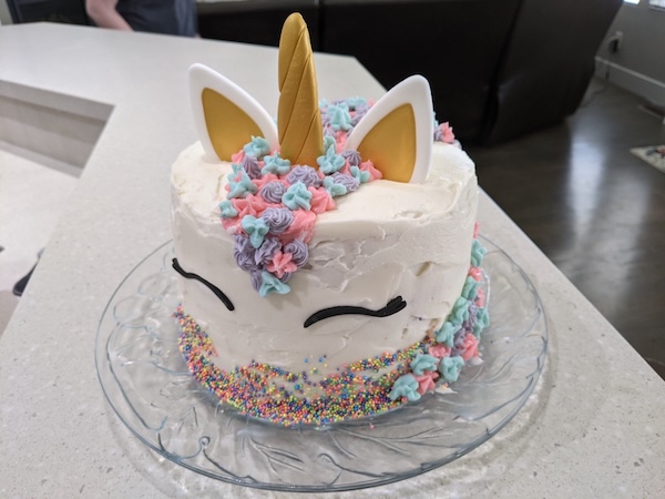 Front of a round cake decorated as the head of a unicat