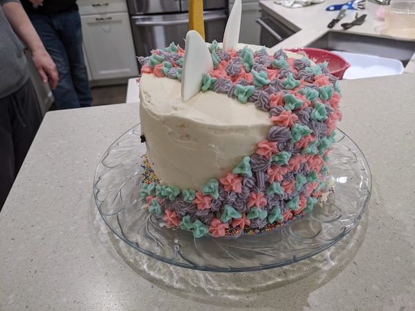 Back of a round cake decorated as the head of a unicat